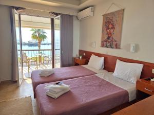 a hotel room with two beds and a balcony at Coco's Corfu Apartments in Ipsos