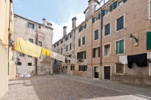 an empty street with clothes hanging from buildings at In the heart of Venice in Venice