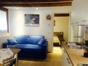 a living room with a blue couch and a kitchen at In the heart of Venice in Venice