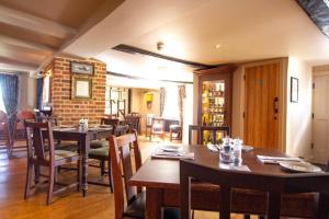 a dining room with wooden tables and chairs at The Cherry Tree Rochford in Rochford