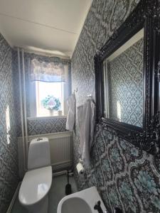 a bathroom with a sink and a toilet and a window at Skärplinge Gästis B&B in Skärplinge +25 photos