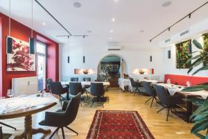 a dining room with tables and chairs and red walls at Hotel Restaurant Pusswald in Hartberg