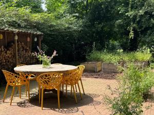 a table with chairs and a vase of flowers on it at Tinkerbell in Oosterbeek