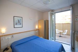 a bedroom with a blue bed and a balcony at Hotel Delle Mimose in Diano Marina