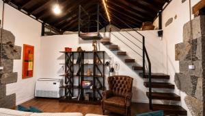a staircase in a living room with a chair at Finca La Acequia del Gamonal in Santa Brígida