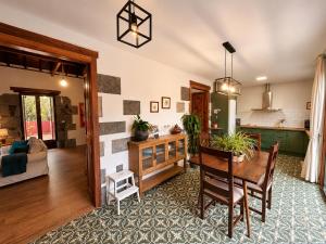 a living room with a table and a kitchen at Finca La Acequia del Gamonal in Santa Brígida