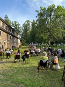 a group of people sitting in chairs in the grass at Park Hotel Brūzis in Smiltene +23 photos