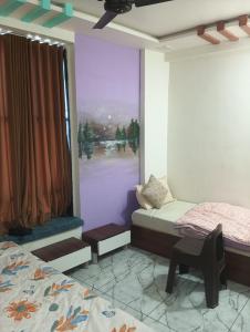 a bedroom with two twin beds and a window at hotel shaurya in Naroda
