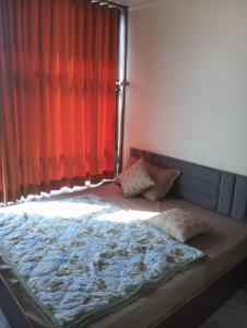 a bed in a bedroom with a red curtain at hotel shaurya in Naroda