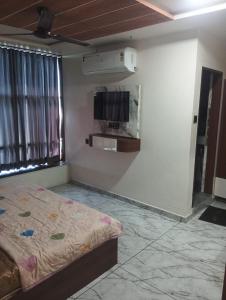 a bedroom with a bed and a tv on the wall at hotel shaurya in Naroda +10 photos