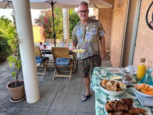 a man standing in front of a table with a plate of food at Villa Flamingo GAYmen only b&b in Marseillan