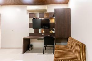 a room with a desk with a tv and a chair at Hotel Ashish in Ahmedabad