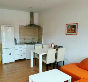 a kitchen and dining room with a table and a couch at Apartments Eis in Baška