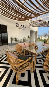 a patio with a table and chairs on a rug at NestSort Hotel in Mysore