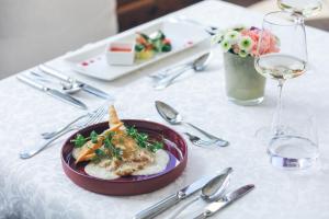 a table with a plate of food on a white table cloth at Hotel Steiner Superior in Obertauern