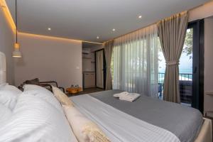 a bedroom with two beds and a large window at The Olive Garden in Shkodër