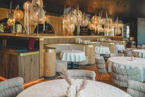 a restaurant with white tables and chairs and lights at Hotel Steiner Superior in Obertauern