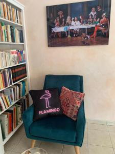 a green chair with a pillow on it in a library at Villa Flamingo GAYmen only b&b in Marseillan