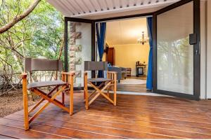 two chairs on the porch of a house at Mazuri Bush Cottages in Hluhluwe