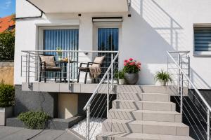 a staircase with two chairs and a table on a house at Gelbe Koffer - Design-Apartment in Schiffweiler - 2 Parkplätze - Self-Check-in - ruhig & naturnah in Schiffweiler