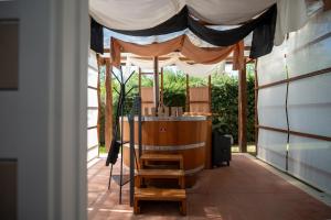 a porch with a tent and a wooden table at Rifugio diVino Dormire in una botte - Wine Barrel stay near Rome in Rieti