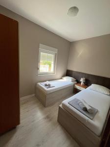 a bedroom with two beds and a window at Luxury Villa with Private Pool and Jacuzzi in Mostar