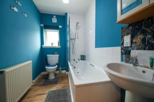 a bathroom with a toilet and a tub and a sink at Surfer 2Bed GF Flat Central Thurso, Parking, Fibre in Thurso