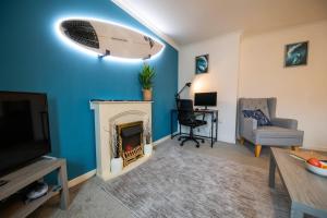 a living room with a surfboard on the wall at Surfer 2Bed GF Flat Central Thurso, Parking, Fibre in Thurso
