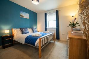 a bedroom with a bed with a blue wall at Surfer 2Bed GF Flat Central Thurso, Parking, Fibre in Thurso