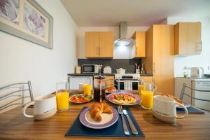 a kitchen with a table with food and orange juice at Surfer 2Bed GF Flat Central Thurso, Parking, Fibre in Thurso +4 photos