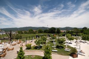 a park with white chairs and tables and trees at Vrnjačko Vrelo Resort in Novo Selo