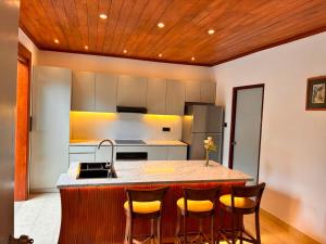 a kitchen with a large island with bar stools at Lullaby Marine Villa in Wadduwa +10 photos