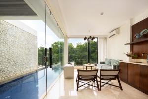 a swimming pool in a living room with a table and chairs at The Sterling Villas in Uluwatu