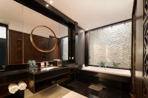 a bathroom with a tub and a sink and a mirror at The Sterling Villas in Uluwatu