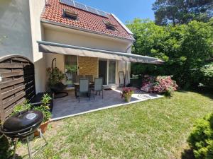 a patio with chairs and a table in a yard at Fenyves Ferienhaus 2 **** in Balatonfenyves