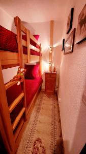 a room with two bunk beds and a red couch at Studio de montagne - résidence le saphir in Puy-Saint-Vincent