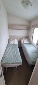 a small room with two beds and a window at E21 The Sandy Heaven in Lossiemouth