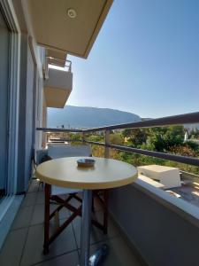 a table on a balcony with a view of the ocean at Peania Domus in Paianía