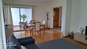 a living room with a couch and a table and chairs at Apartamento Lombinha in Vila Franca do Campo