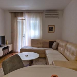 a living room with a couch and a table at Bright & Spacious Apartment Budva in Budva