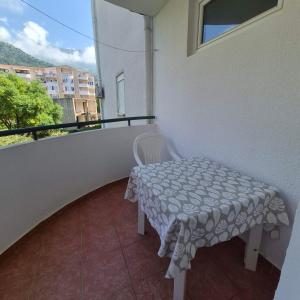 a small table and chair on a balcony at Bright & Spacious Apartment Budva in Budva