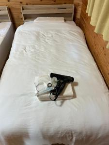 a bed with a pair of glasses and a book on it at Sea Sky 赤崎 in Yoron