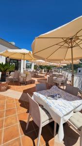 a patio with tables and chairs and umbrellas at Residenz e Ristorante da Mimì in Forio d'Ischia