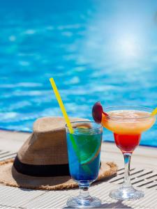 two cocktails on a table next to a swimming pool at Adella Garden Marina Hotel in Güvercin Adası