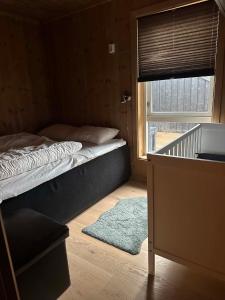a bedroom with a bed and a window with a rug at Harevadet 221 in Volda