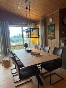 a dining room table with chairs and a light fixture at Harevadet 221 in Volda