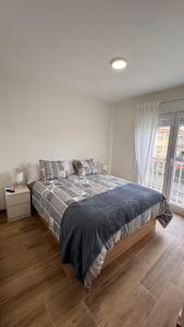 a bedroom with a large bed in a white room at AuraGalega Noro in Ribeira