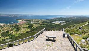 a bench sitting on top of a mountain overlooking the water at AuraGalega Noro in Ribeira