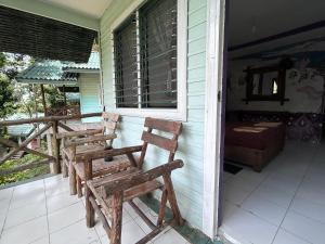 two wooden chairs sitting on the front porch of a house at Chill Out Bar and Bungalows in Tonsai Beach