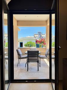 a patio with a table and chairs on a balcony at Ionian Waves Villa - Marathopoli Stylish Escape in Marathopoli